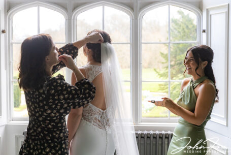 Nicole's veil being fitted with a bridesmaid looking on. Ashridge House wedding.