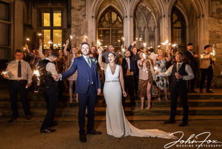 Bride and Groom with guests and sparklers outside Ashridge House. Hertfordshire wedding photography by John Fox