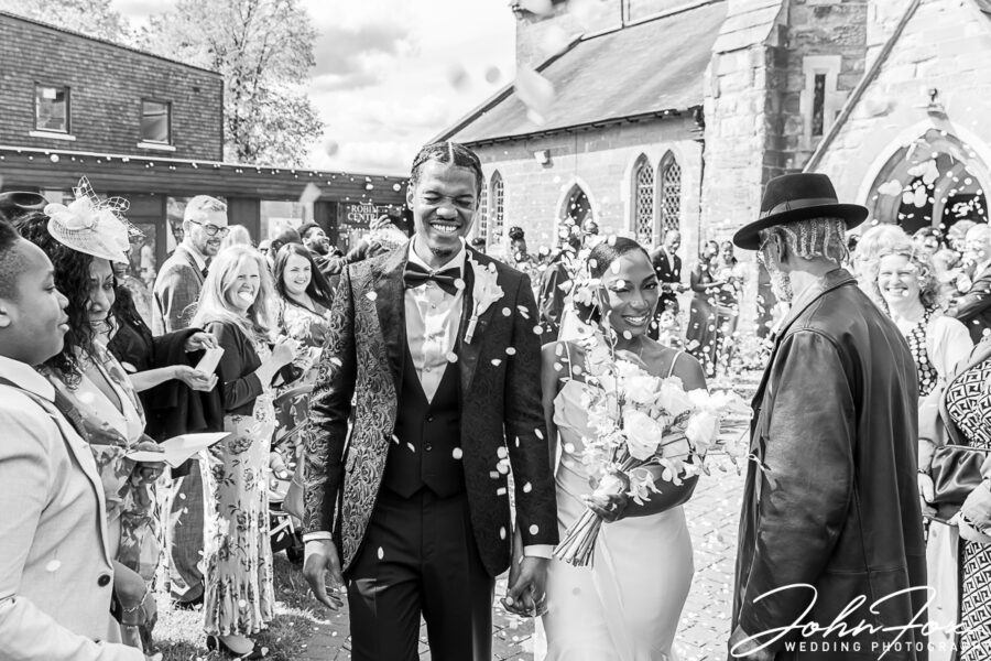 Confetti being thrown over the bride and groom outside the church in Kings Heath, Birmingham