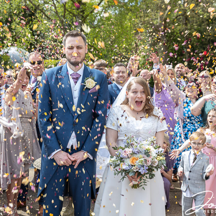 Confetti being thrown over the bride and groom. John Fox Wedding Photography.