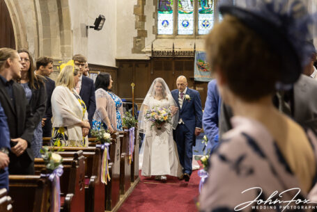 The bride and her father walking up the aisle.
