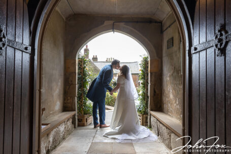 Bride and groom kissing at the church entrance in Markfield, Leicestershire