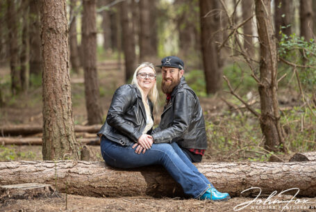 Verity and James sitting together on a fallen tree.