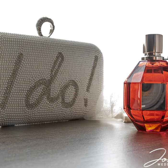 A purse with I Do! written on the side and a bottle of perfume