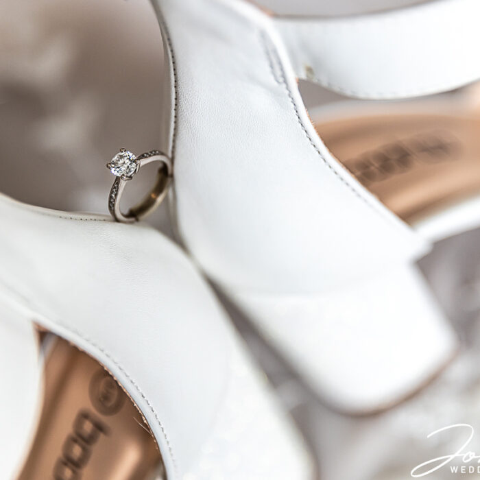 A wedding ring perched on the bride's shoes at The Barns at Hunsbury Hill, Northamptonshire