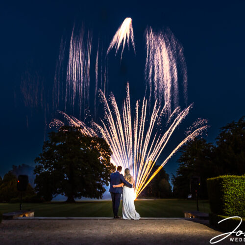 Bride and Groom, Zoe and Joshua, watching fireworks at Ashridge House as part of their wedding day celebrations. Image by John Fox Wedding Photography.