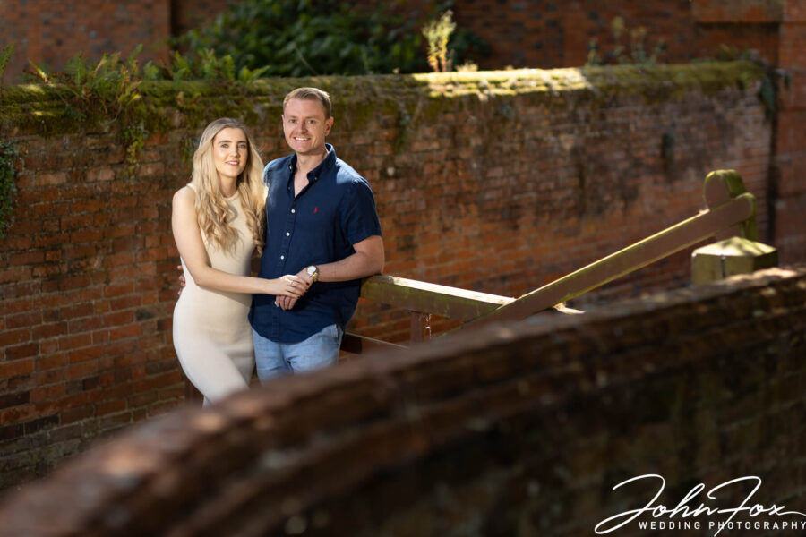 The happy couple leaning on a gate for their pre-wedding shoot in Buckinghamshire.