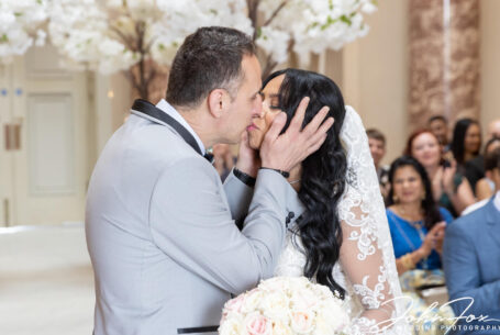 The Groom kisses the Bride. Photo by John Fox Wedding Photography