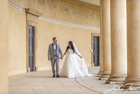 The bride and groom hand-in-hand in the grounds at Stowe House.