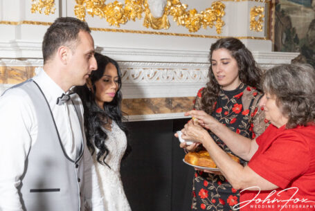 The Groom's mother offers the bread she has baked to the newly-wed couple.