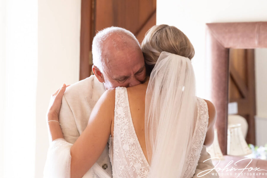 Father and daughter hold each other before the ceremony. Photo by John Fox Wedding Photography
