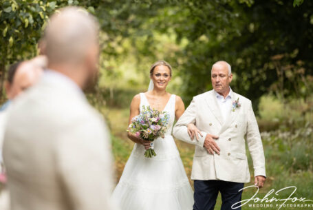 Father and Bride walking to the outdoor ceremony. Photo by John Fox Wedding Photography.