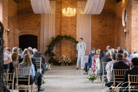 The groom waiting for the bride at the wedding ceremony at Meadow Barn, Stratford-upon-Avon