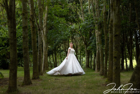The bride in the woodlands at The Stratford Park Hotel. Photo shoot by John Fox Wedding Photography.