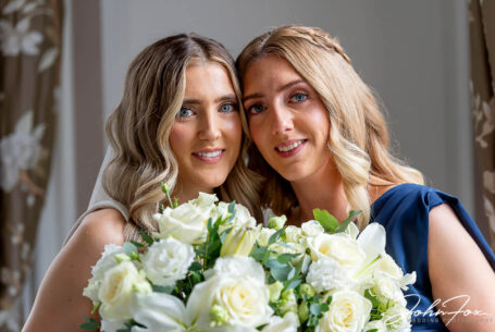 Lorna and her sister with a bouquet of flowers, just before the wedding ceremony at Chicheley Hall in Buckinghamshire