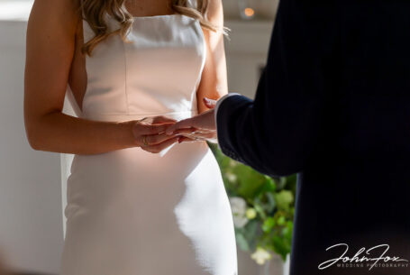 Lorna and James exchanging rings at their wedding ceremony at Chicheley Hall in Buckinghamshire
