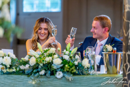 Lorna and James toasting their wedding with glasses of bubbly. Wedding photographer at Chicheley Hall, Buckinghamshire.
