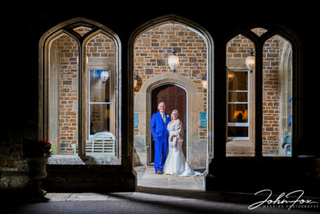Night time image of a bride and groom at the entrace of Fawsley Hall.