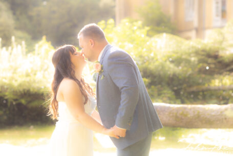 Bride and groom share a kiss in the grounds of Missenden Abbey
