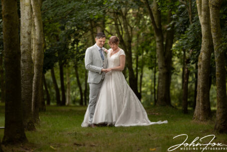 Wedding Photographer Coventry and Warwickshire. Bride and groom pictured in woodland looking at wedding ring.