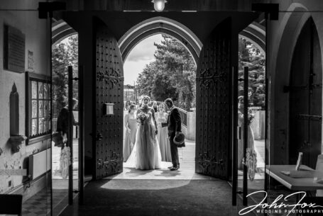 Bride and father with bridesmaids at the entrance to the church in Derbyshire