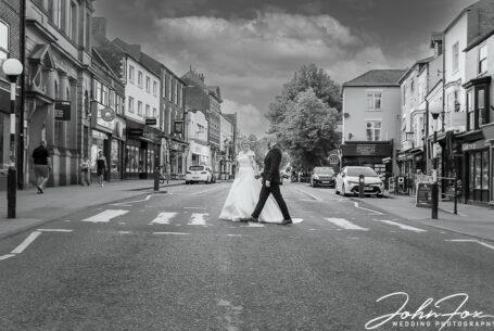 Bride and Groom in the centre of Market Harborough crossing the road like The Beatles' Abbey Road iconic image