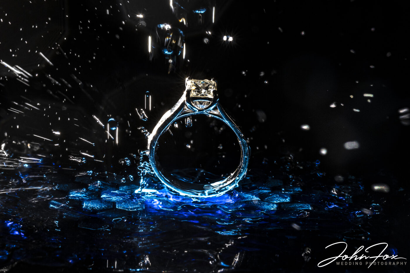 Celebrate a Christmas engagement with a photo shoot. Engagement ring creative photograph with water.