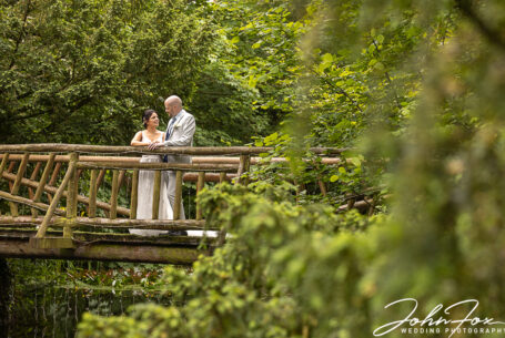 The wedded couple on a bridge at Cheltenham’s Manor by the Lake. Image by John Fox