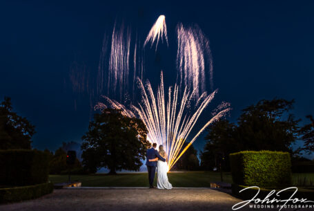 Bride and Groom with fireworks display at Ashridge House. Image by John Fox Wedding Photography