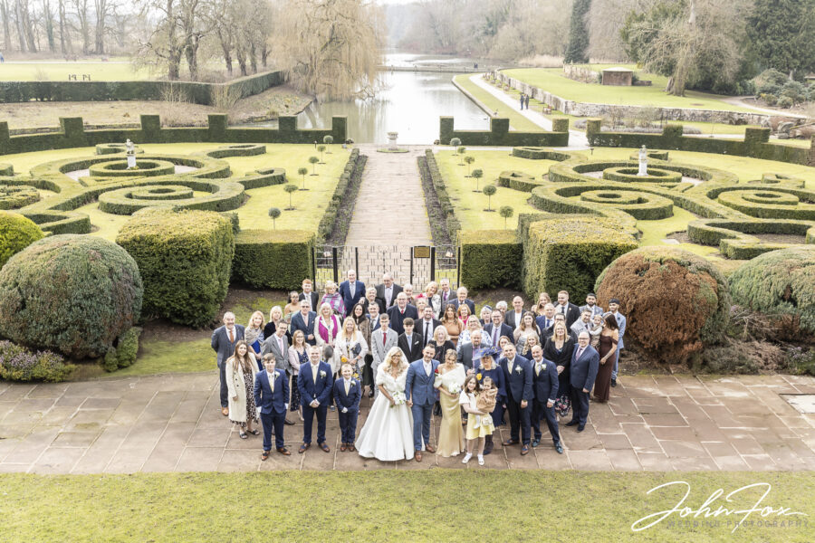Photograph of all the wedding guests at Coombe Abbey showing the gardens and lakes on Valentine’s Day