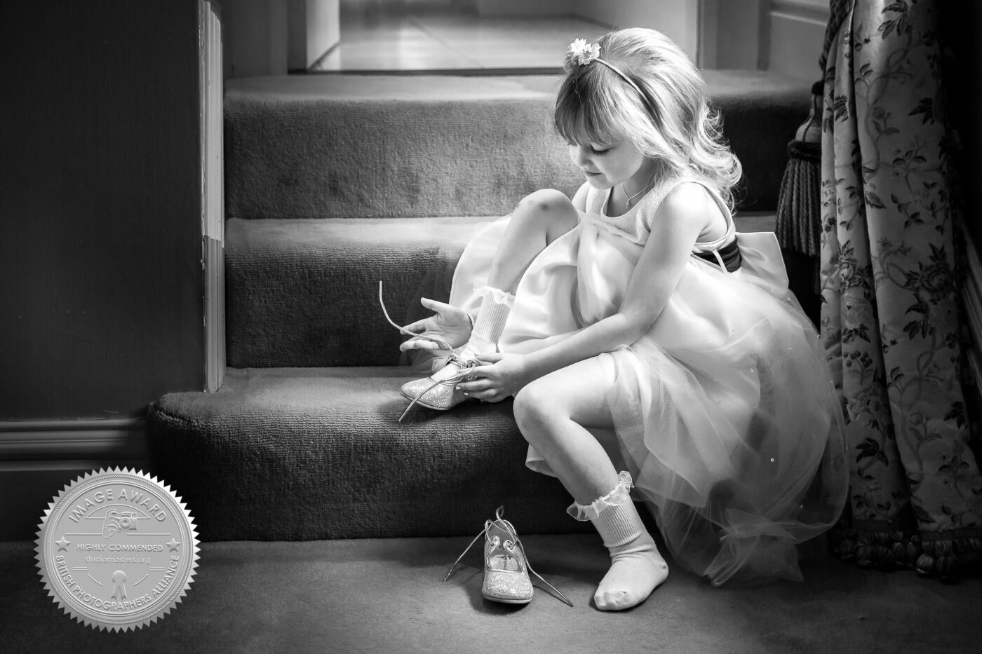 Highly Commended Award to John Fox Wedding Photography. The winning image of youngster tying her shoelaces at Kilworth House.