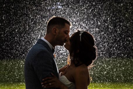 Bride and groom kissing in the rain. The Venue Group and John Fox Wedding Photography