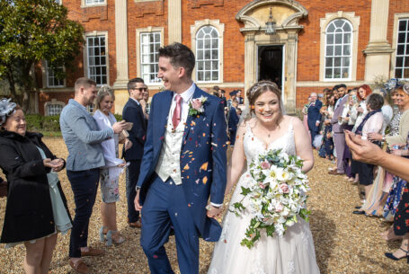 Bride and Groom walking through people throwing confetti