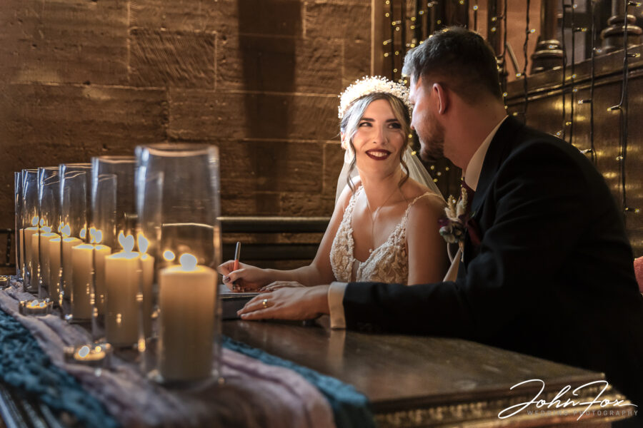 Signing the register by candle light at Peckforton Castle