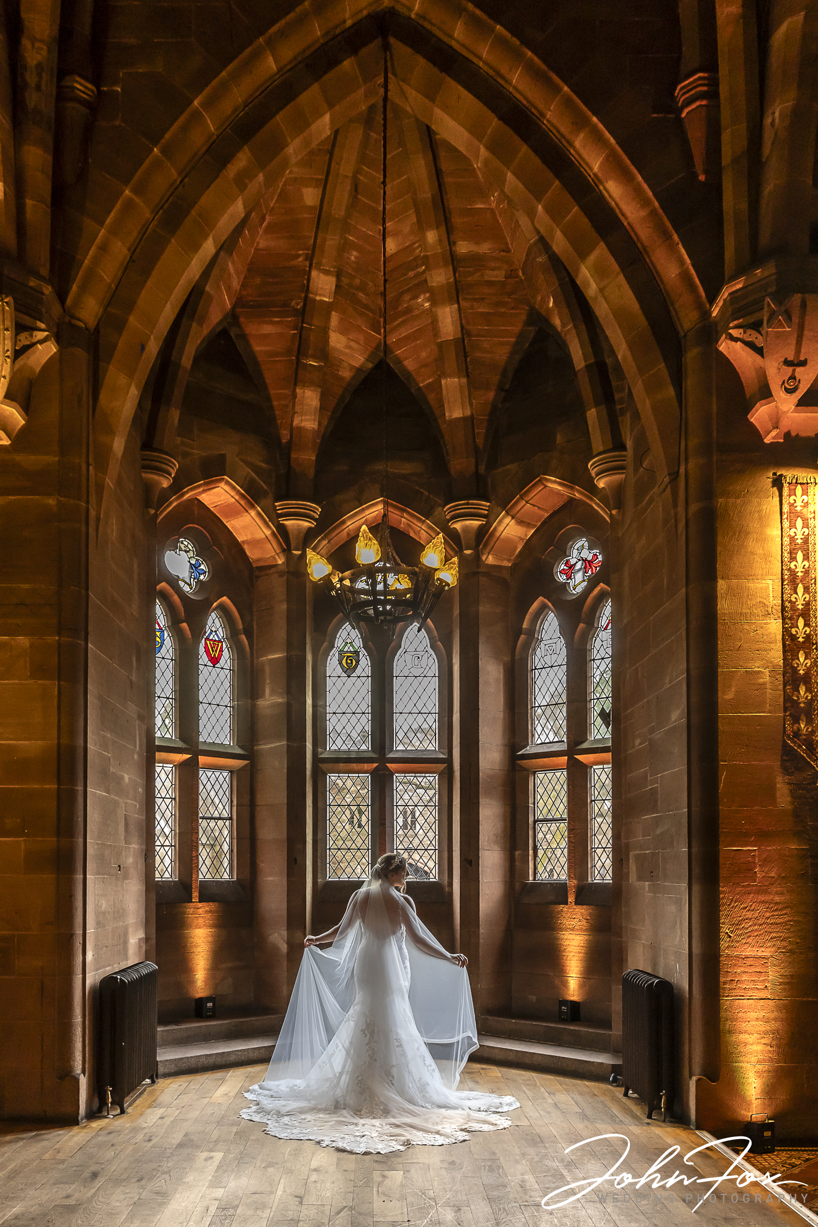 Bride in an arched window setting at Peckforton Castle