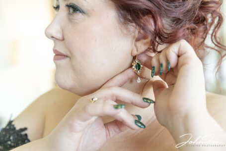 Bride putting her earing in during wedding preparations