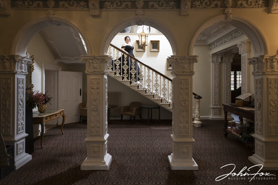 Bride coming down the stairs at Ettington Park in Warwickshire