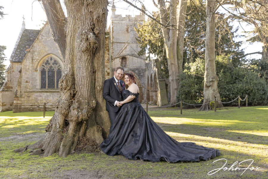 Bride and groom in the grounds by the church ruins at Ettington Park