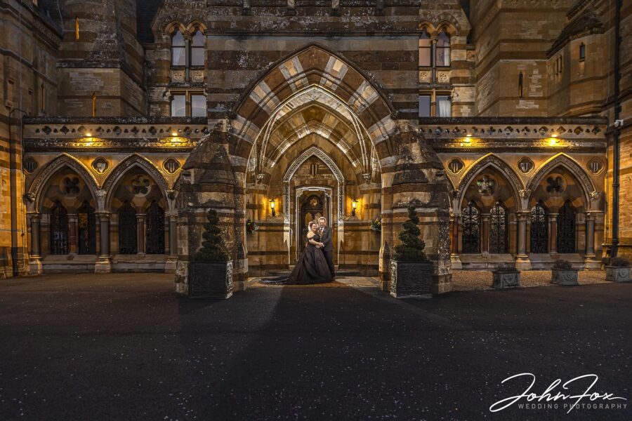 Warwickshire Wedding Photographer: Bride and groom at night in the entrance of Ettington Park Hotel