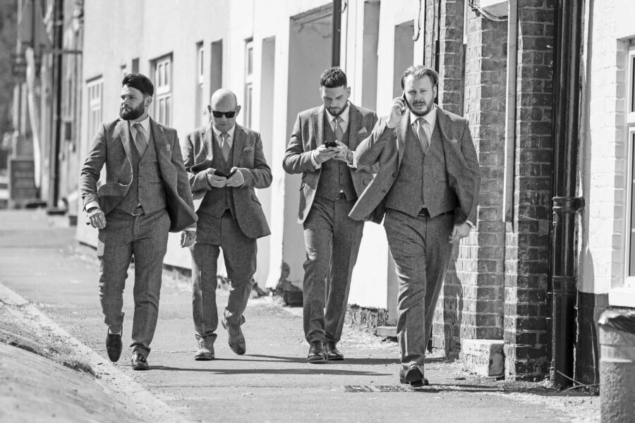 Groom and groomsmen on their phones and on their way to the church