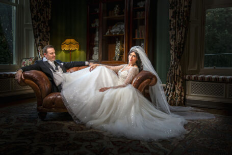 Posed image of the bride and groom on a sofa. Image by John Fox