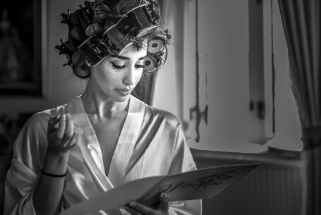 Bride reading a card from her soon to be husband while she prepares for the ceremony
