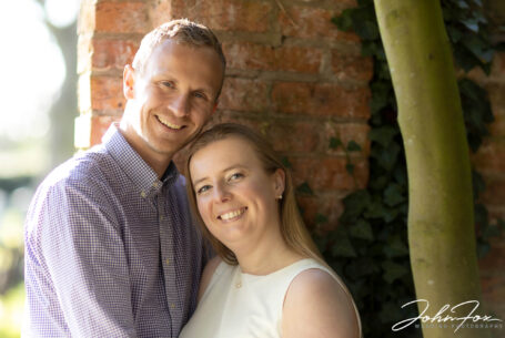 Happy couple on their pre-wedding shoot at Ansty Hall near the garden gate using bounced light