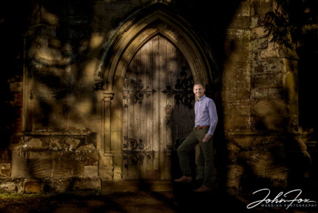 Groom to be on his pre-wedding shoot at Ansty Hall using the church doorway and sunlight