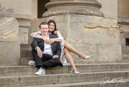Couple sat on stone steps on their prewedding shoot in Oxford.