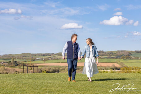 Bride and groom walking; showing view from Primrose Hill Farm in Oxfordshire