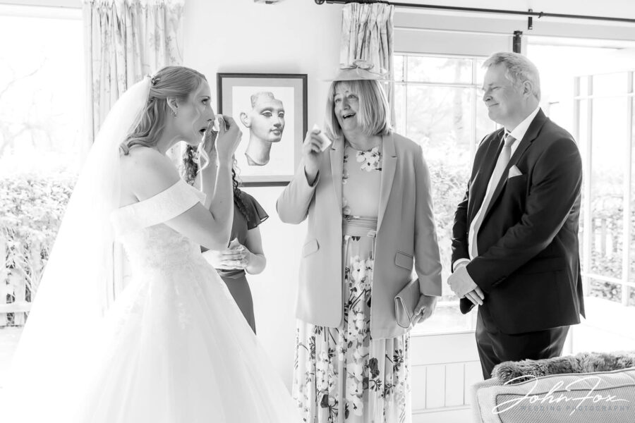 Wedding photography Wiltshire. Bride and parents holding back the tears after bride reveal.