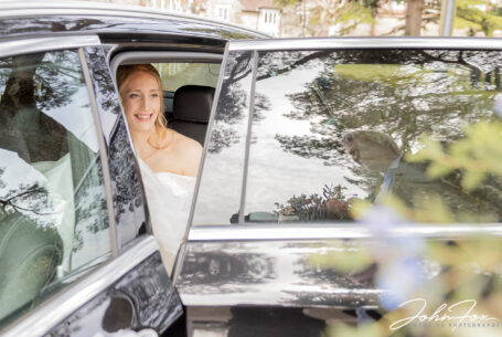Wedding photography in Wiltshire. Bride in the wedding car and dad's reflection in the window.