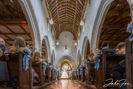 Image of bride and groom with the vicar during church wedding ceremony by John Fox Wedding Photography