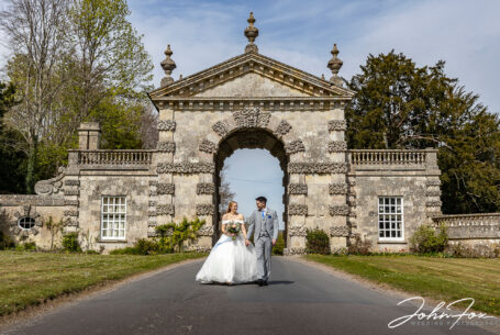 Bride and groom walking near an arch